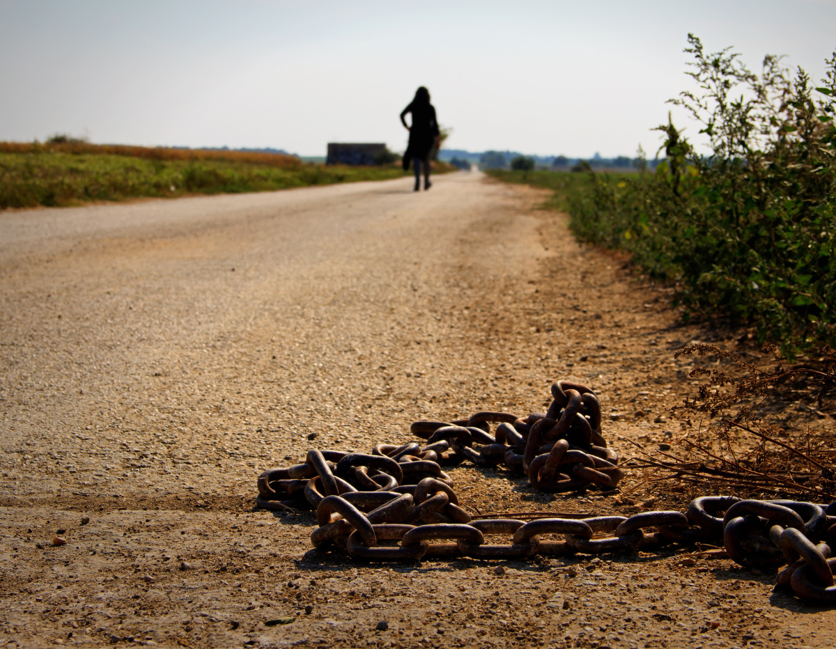 rusted iron linked chain on dirt road
