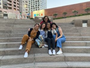 Seated outdoors, on steps, the five members of the Restorative Justice Project
