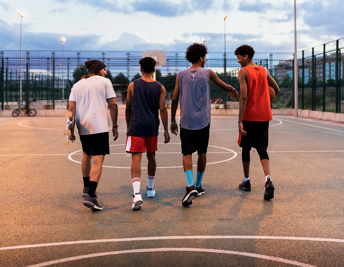 group of teenagers standing on basketball court